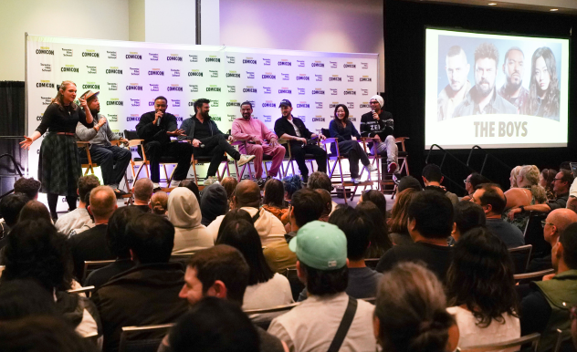 An image of the cast of The Boys sitting on directors chairs on stage. Left to right - Interpreter, Moderator Victor Dandrige, Jessie T. Usher, Karl Urban, Laz Alonso, Tomer Capone, Karen Fukuhara, Antony Starr