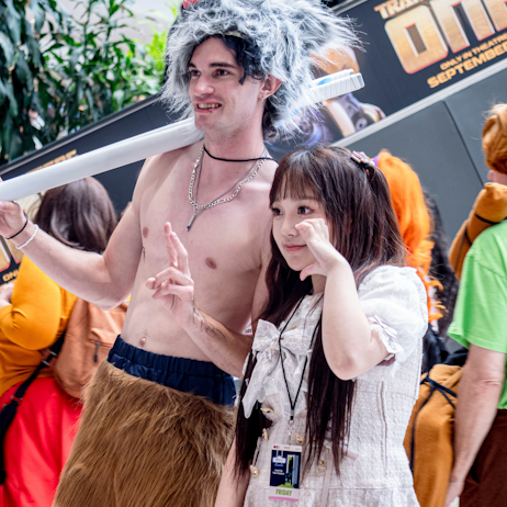 Fans, dressed as characters from different animes, pose together for a photo on the show floor. 