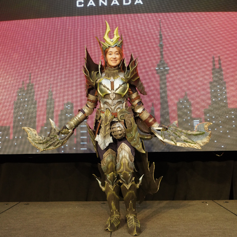 Our Cosplay Grand Prix Maple Leaf winner Cerulea Cosplay poses in her Acidic Glavenus Armour in front of the red and black FAN EPO Canada background.