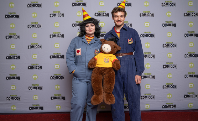 Cosplayers dressed as Anya and Jimmy from Mouthwashing pose with a stuffed horse. 