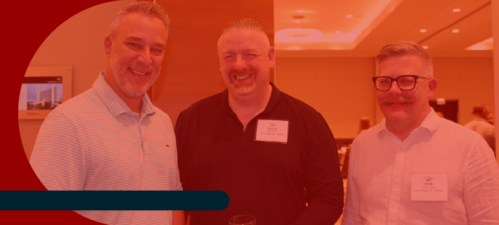 Attendees smiling at the camera after a general session break.