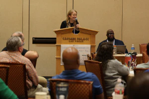 Speaker presents practical AI strategies to a full audience during an AI in Action session at HDI Service & Support World.