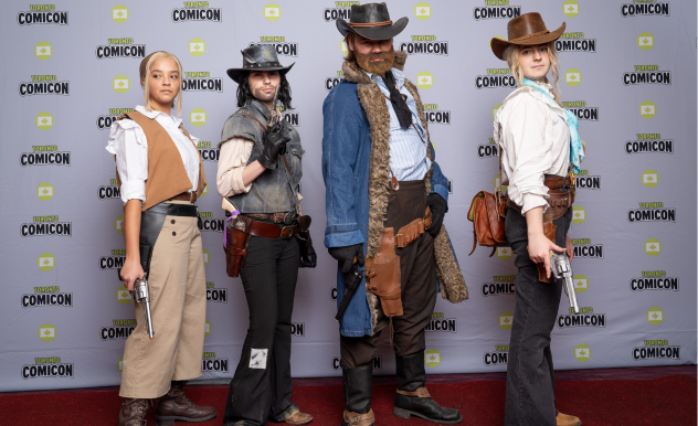 Four cosplayers dressed as cowboys pose confidently on the red carpet. 