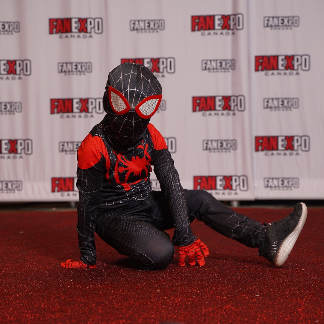 Young child poses in a Spiderman costume on the red carpet