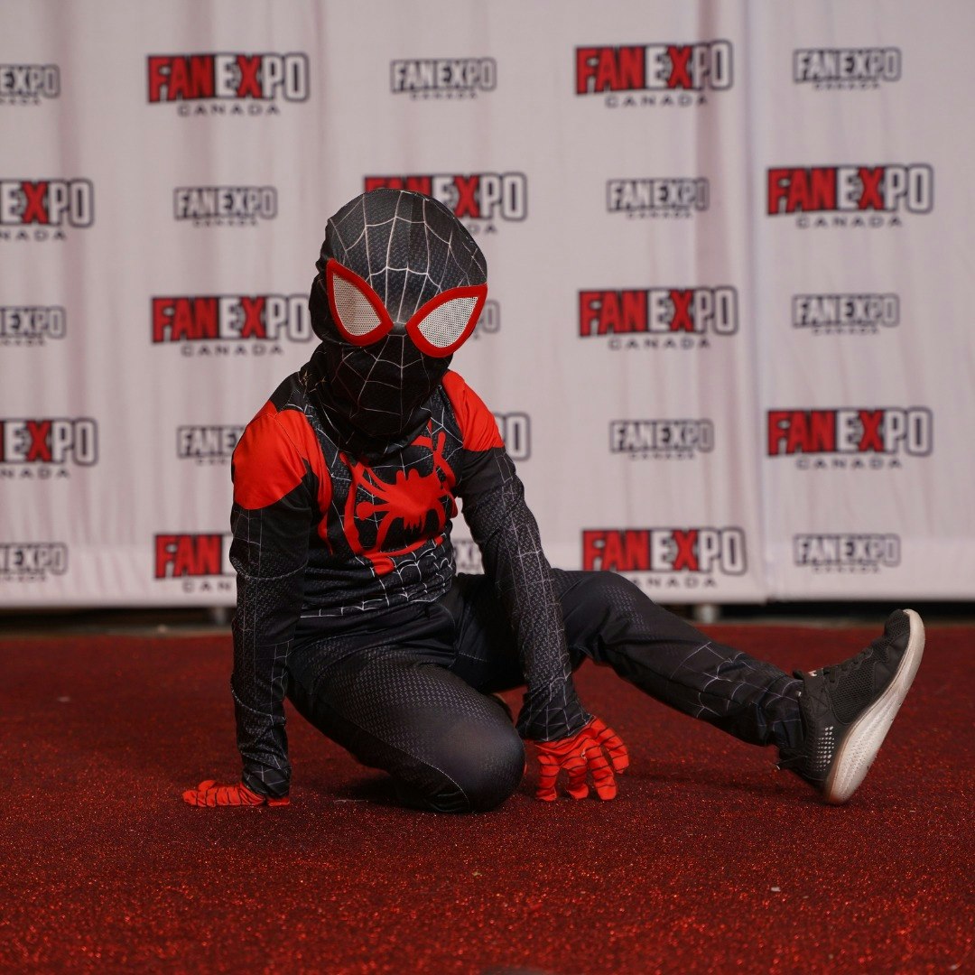 Young child poses in a Spiderman costume on the red carpet