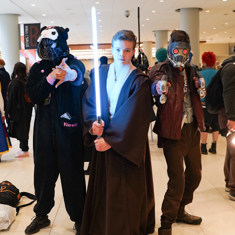Posing together left to right: Spider-Man in a Kuromi Kigurumi, Obi-Wan Kenobi (with a lit saber) and Star Lord, pointing his blaster forward