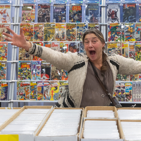 Exhibitor very excited to pose in front of their comic book booth