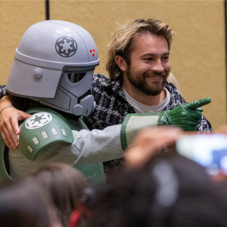 Taylor Gray with his arm around a storm trooper smiling