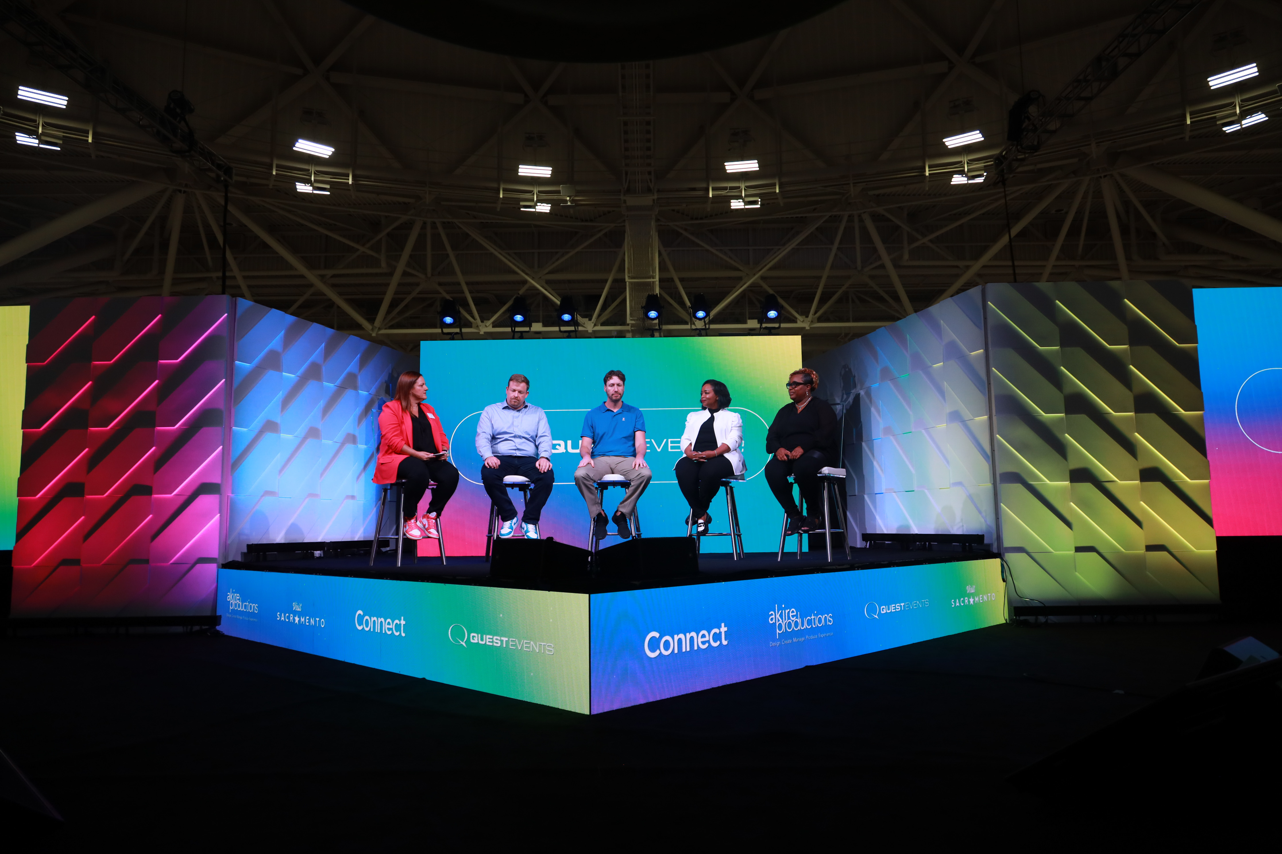 The speaker showcase stage at Connect Marketplace with five people on it participating in a panel discussion.