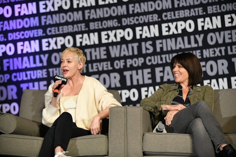 Rose McGowan joins fellow horror icon Neve Campbell on stage. Neve smiles as Rose recounts what it was like to work with the incredible shared cast.