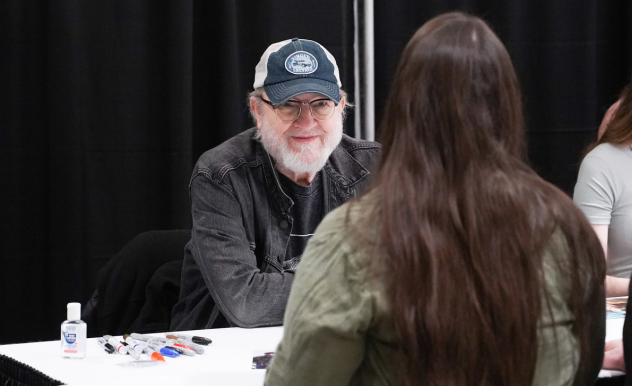 With a fan whose back is facing the camera, Jim Beaver smiles as they have a conversation.