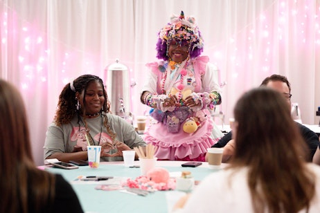 A maid from Maid Cafe smiles for a table of fans