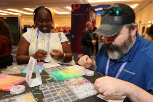 Attendees make friendship bracelets and connect with peers in the HDI Community Corner.