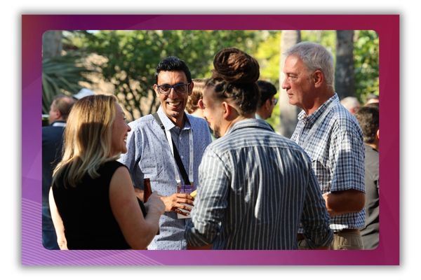Four people standing and chatting at a networking event