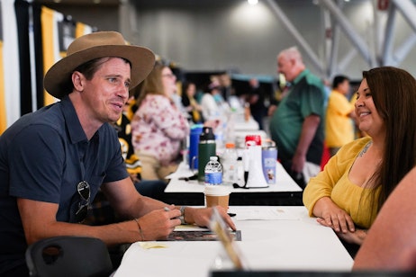 Garrett Hedlund looks at a fan as he signs an autograph