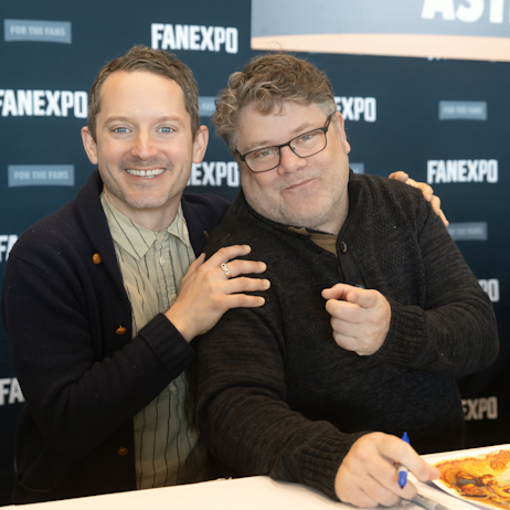 Elijah Wood and Sean Astin posing for a pic together at their booth