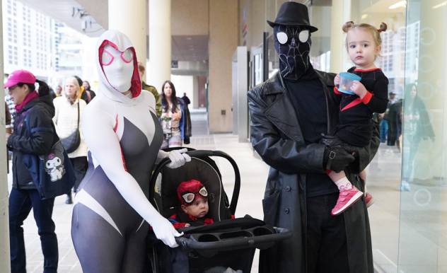 Spider-Fam pose outside of the Metro Toronto Convention Centre - Mom is Ghost-Spider, baby in stroller is Spider-Man, dad is Spider-Noir, and daughter is Miles Morales