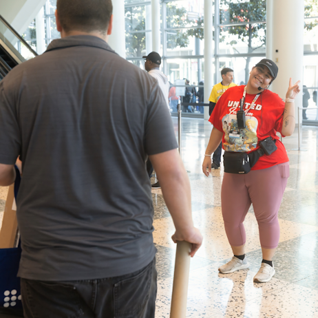 Crew member smiling at a fan with a peace sign