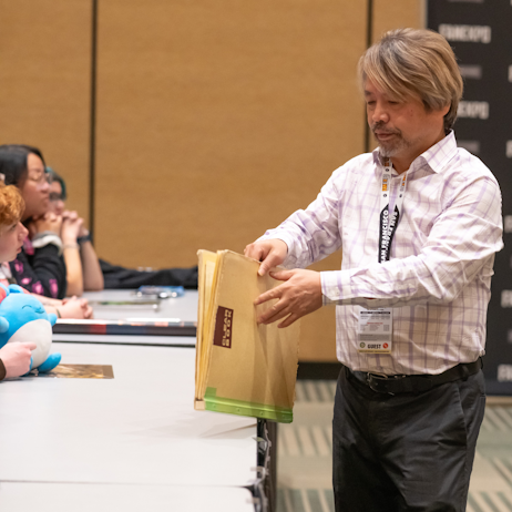 Hirokatsu Kihara opening an art folder