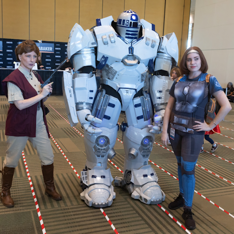Leia, R2D2 Mech (Vader Destroyer) and Bo Katan cosplayers posing for a pic