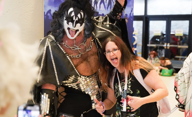 A fan poses for a photo with a cosplayer dressed as Gene Simmons from KISS
