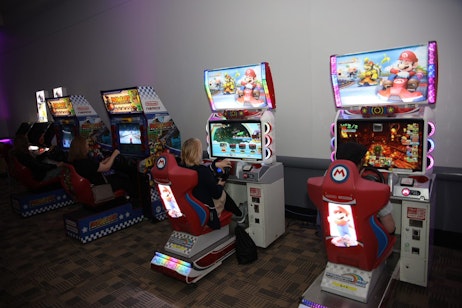 Fans face off in Mario Kart in our Japanese arcade. All chairs are full, and the match is underway