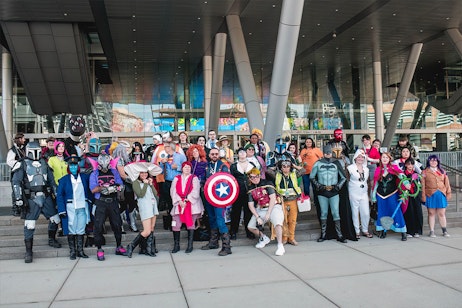A giant group of Cosplayers pose for a photo on the convention entrance steps