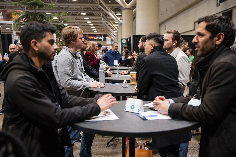 Several small tables of 2 attendees chatting during The Buildings Show Speed Networking sessions