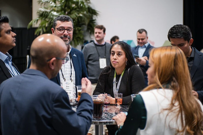 Attendees gathered around a table with a drink during The Buildings Show's Industry Networking Reception