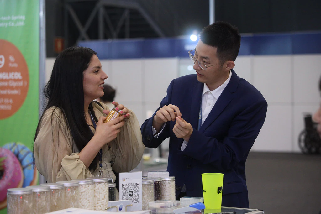 Two visitors talking at an exhibition stand