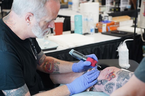 Marc Draven tattooing a fan