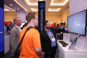 An exhibitor demonstrates a technology solution to attendees in the Expo Hall at HDI Service & Support World.