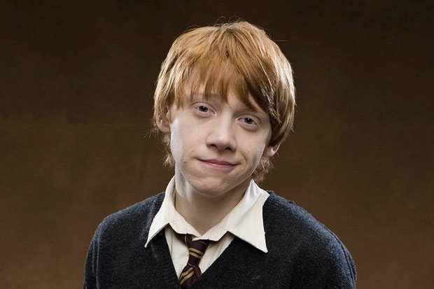 Ron Weasley smiling meakly with a brown background