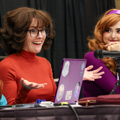 Cosplay panel organizers smile and chat with audience