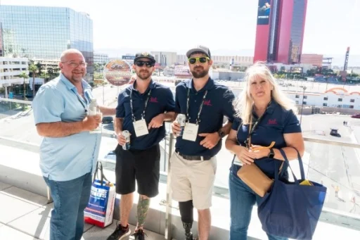 Group of 4 people posing in front of the vegas skyline at the public sector reception balcony