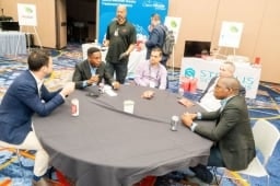 Group of 5 Healthcare Waste conference attendees sitting at a table having discussion
