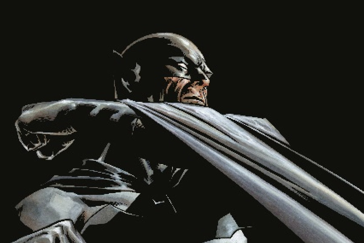 Batman poses with his arm and cape outstretched infront of his face