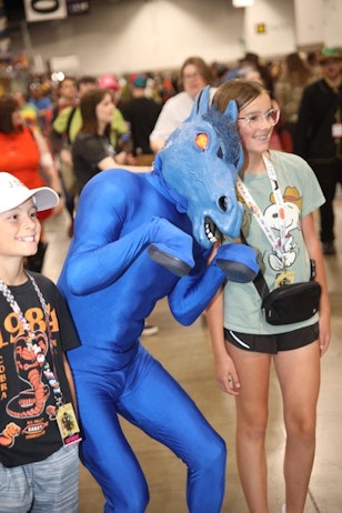 Denver's own Blucifer takes a photo with a pair of young sibings, who are both excited to see the well known horse at FAN EXPO Denver