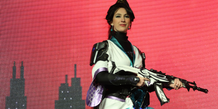 In an armoured kimono, a fan poses holding a white flame gun.