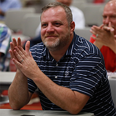 Happy conference session attendee smiling at a table