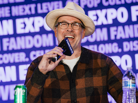 Jason Lee smiling, laughing holding a microphone.