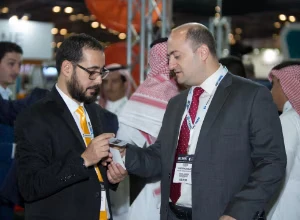 2 men exchanging details at an exhibition.