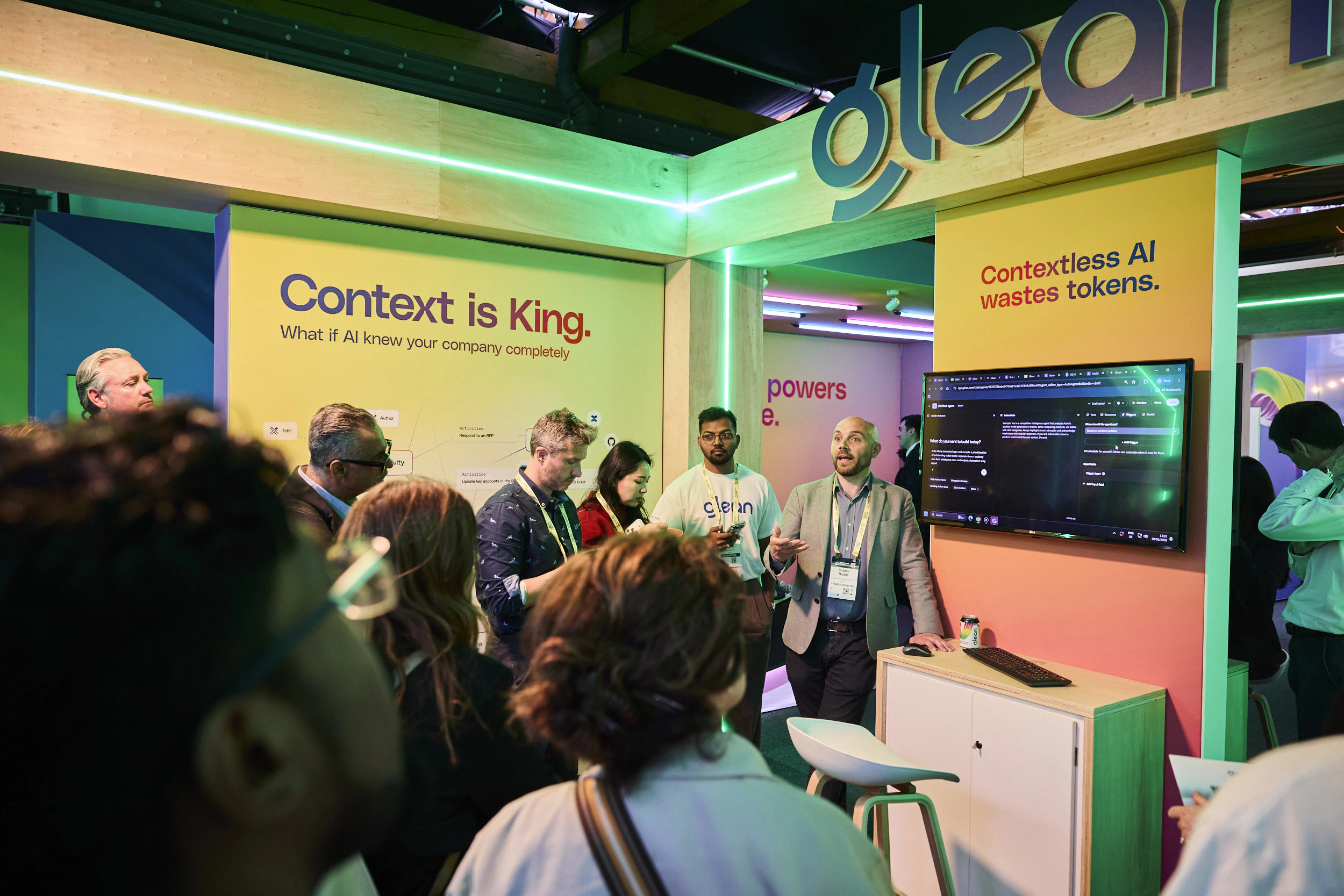 Attendees listen to a talk at Glean booth at The AI Summit London