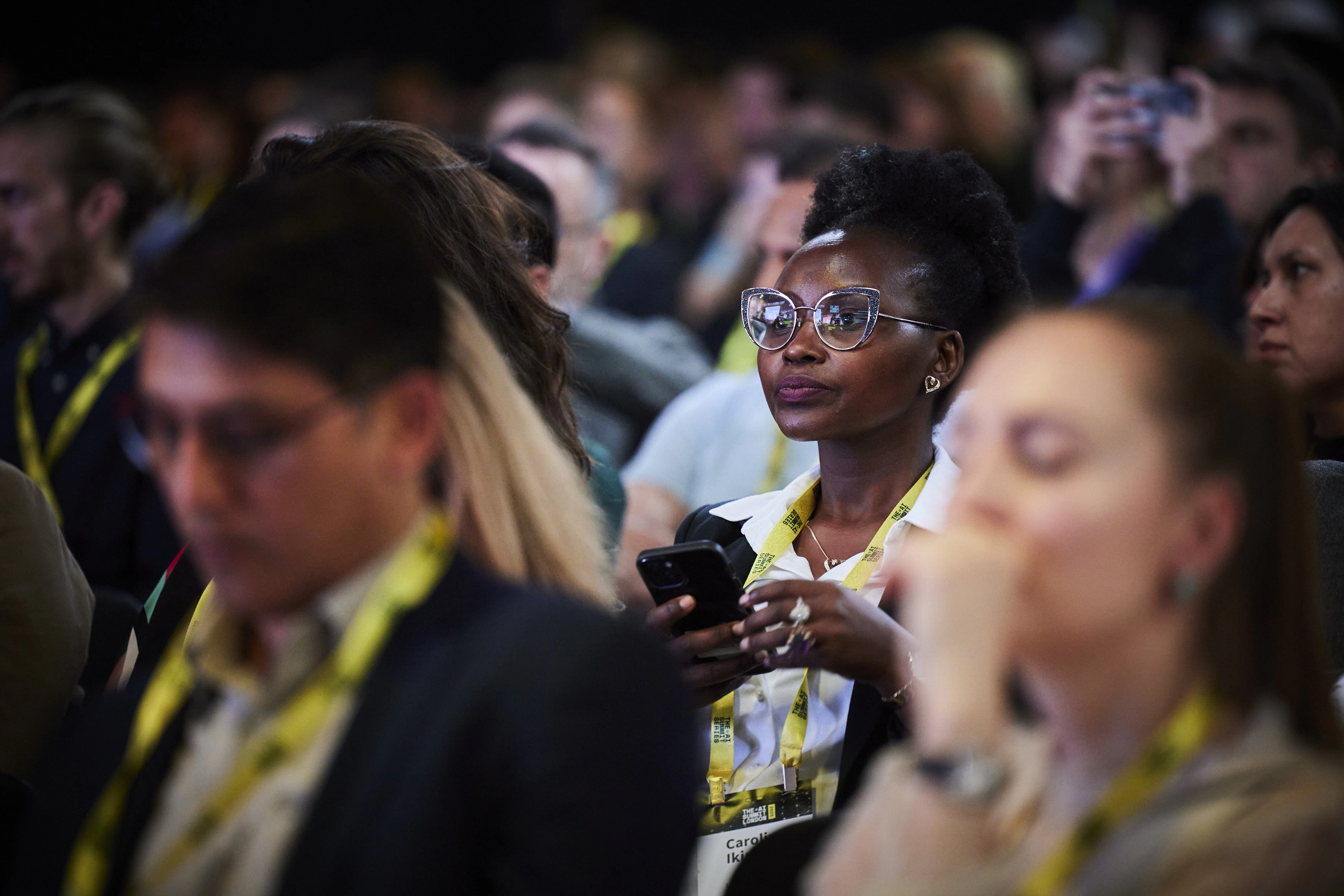 Audience member taking notes on her phone at The AI Summit London