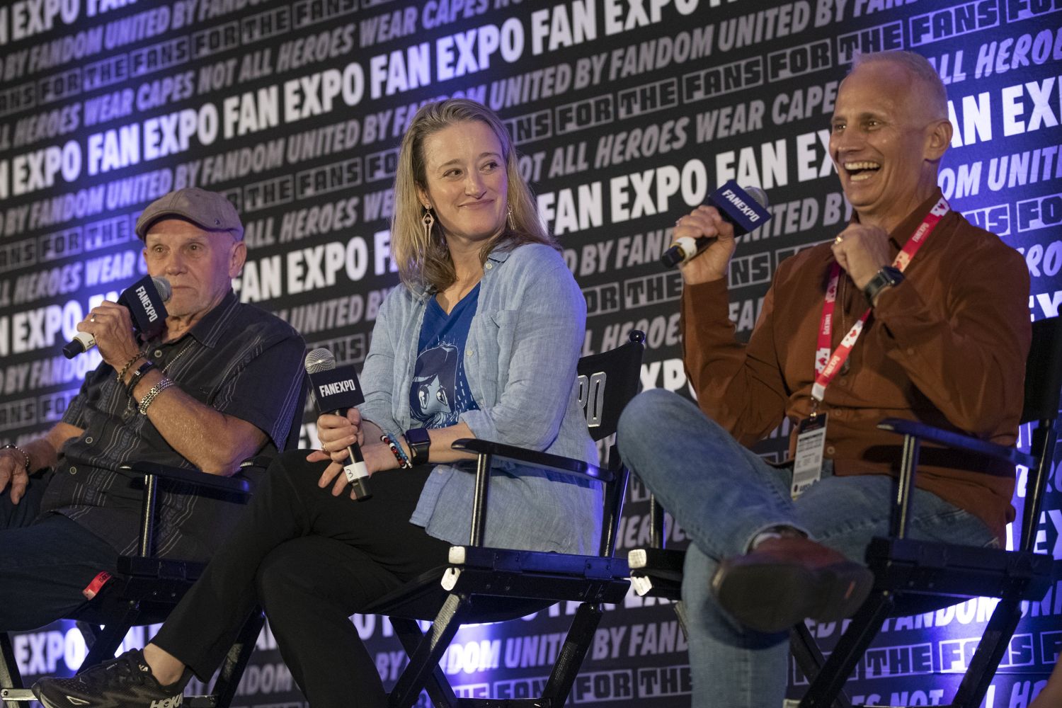Three members of the Halo cast sit together on stage, smiling and laughing while answering questions from fans.