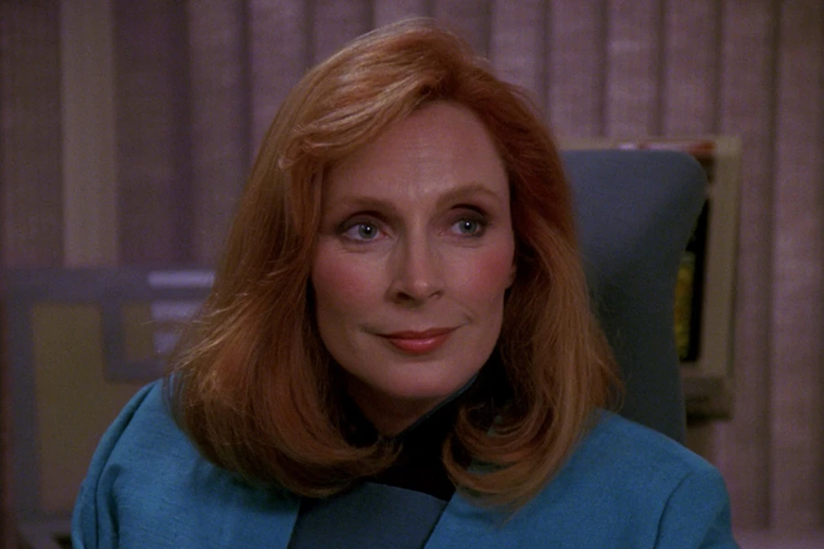 Gates McFadden smiles in a blue blazer from a scene in Star Trek