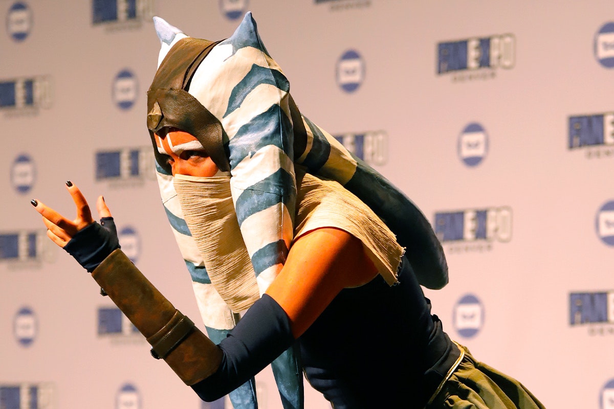 An Ahsoka Tano cosplayer poses with arm extended
