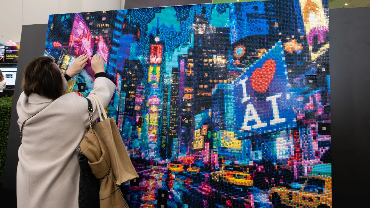 An attendee fits the last bricks of The AI mosaic wall at The AI Summit New York