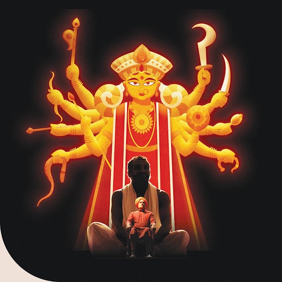 Stage performance featuring a spiritual figure seated in front of a large illuminated depiction of a multi-armed goddess holding various symbolic weapons