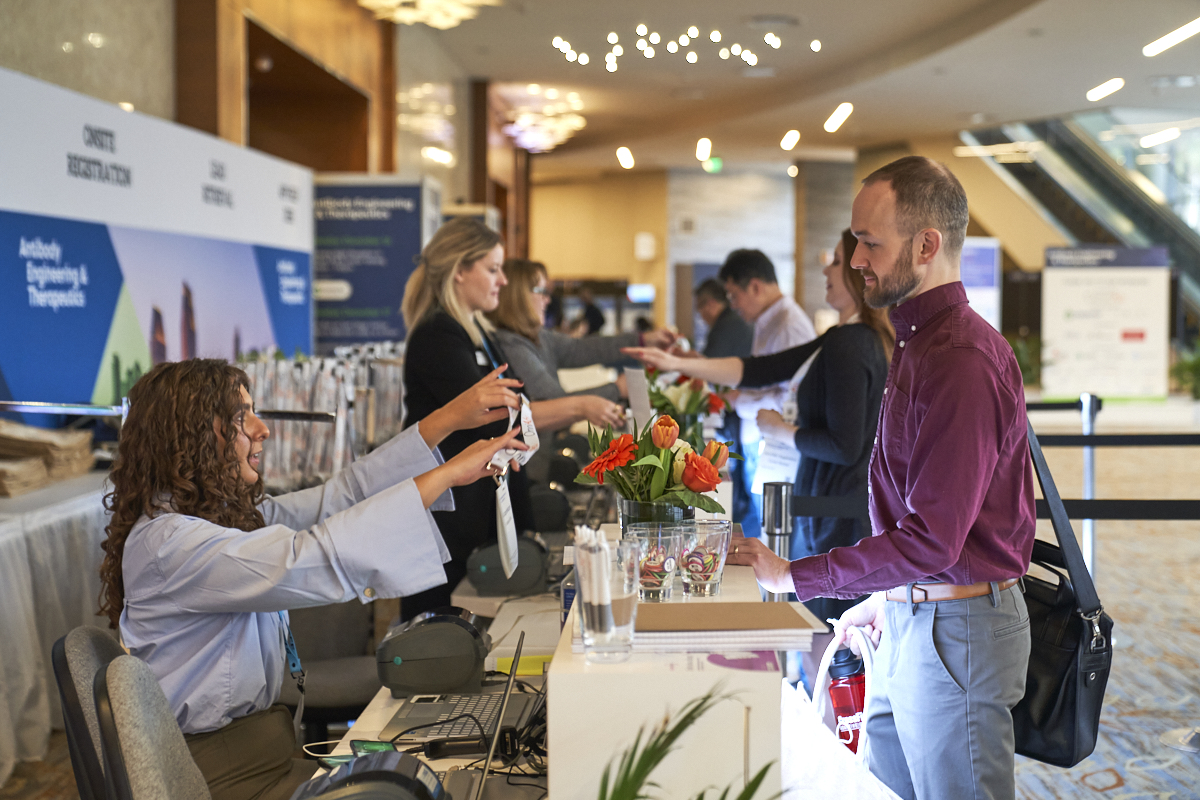 Antibody Engineering & Therapeutics attendee collects their pass at registration